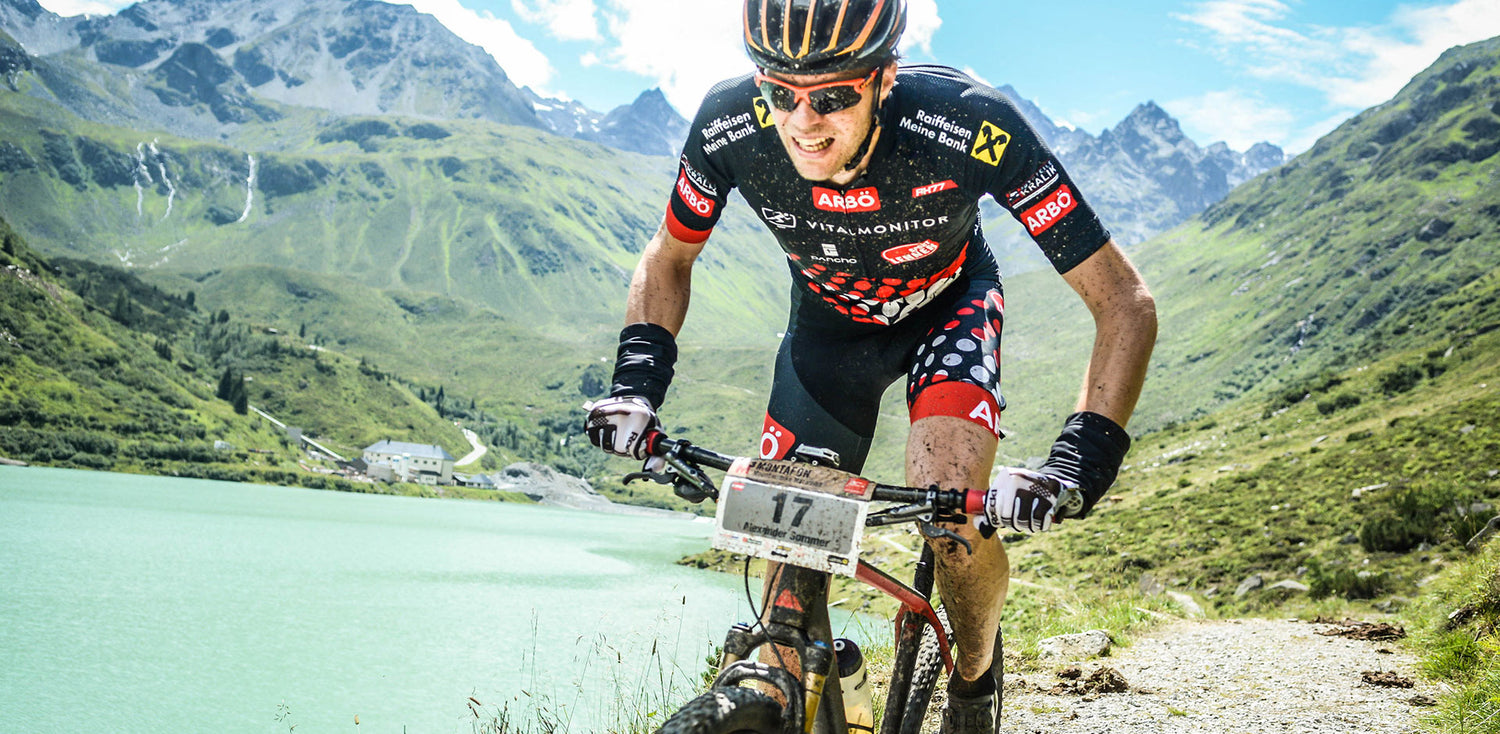 Ein Mountainbiker fährt ein Rennen entlang eines Bergsees