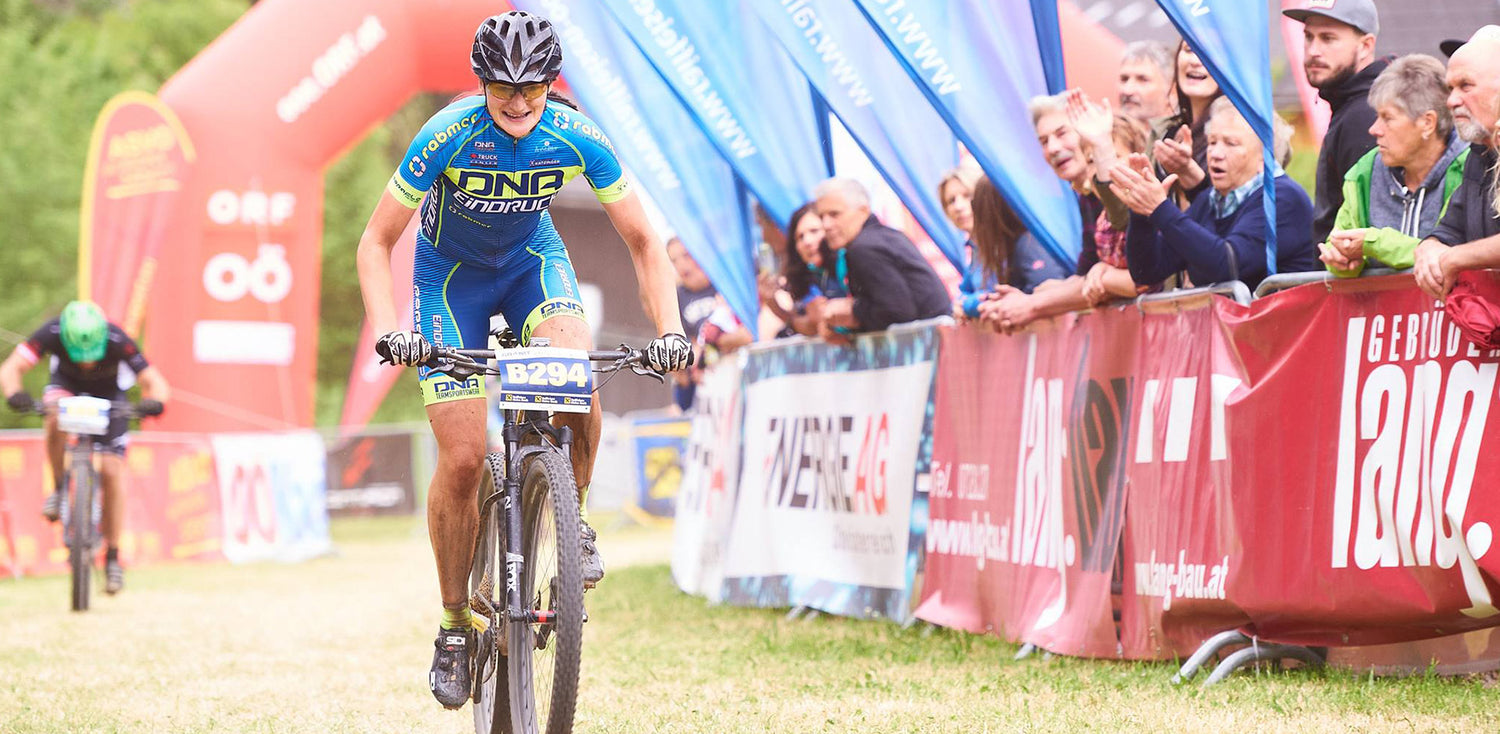 Karoline wird auf dem Mountainbike vom Publikum angefeuert