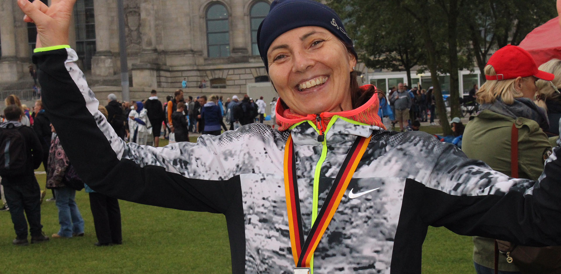 Eine Frau lächelt nach dem Berlin Marathon zufrieden in die Kamera. 